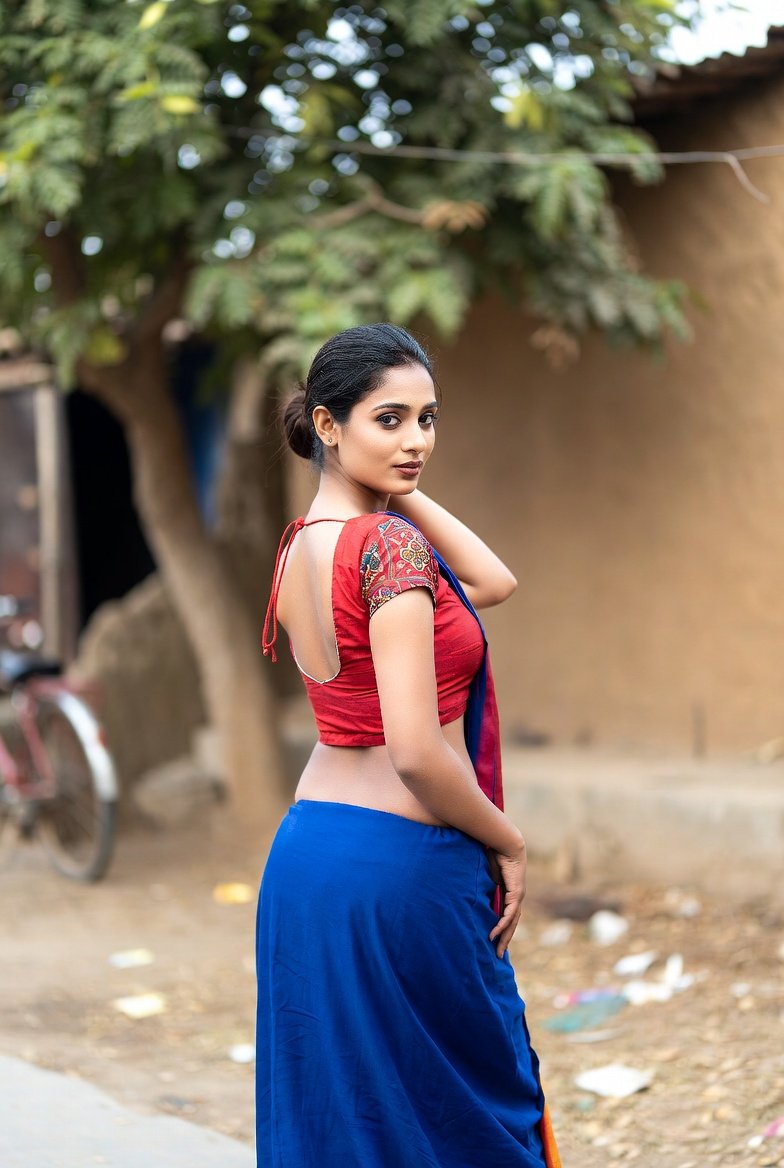 Indian bhabhi posing in red blouse and blue saree outdoors