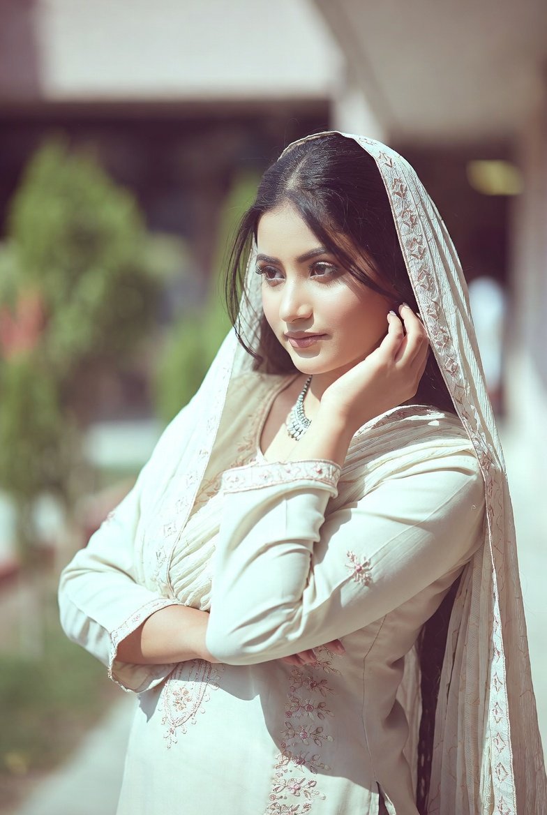 Indian woman in cream salwar suite posing gracefully outdoors