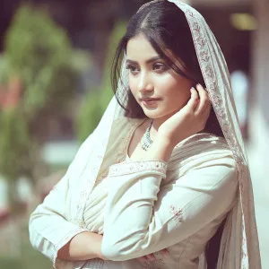 Indian woman in cream salwar suite posing gracefully outdoors