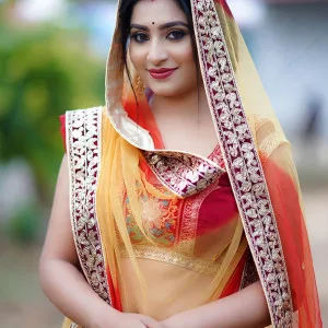 Indian bhabhi in red lehenga smiling outdoors