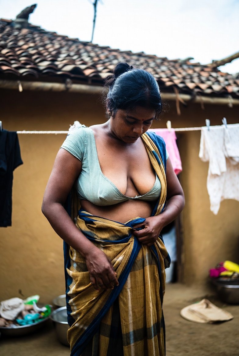 Confident South Indian aunty adjusting saree in rustic village home