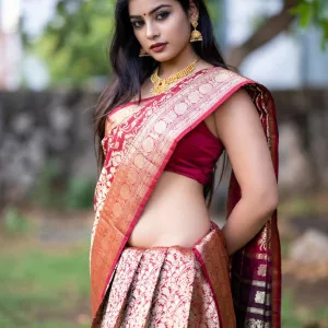 Charming Indian bhabhi in red saree with gold jewelry outdoors
