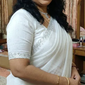 Captivating Indian woman in white embroidered saree smiling brightly