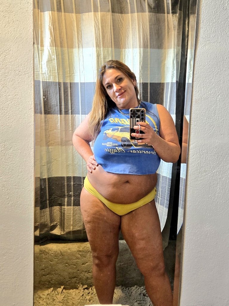 Curvy American woman posing in blue crop top and yellow panties