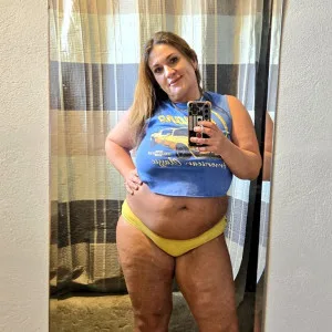 Curvy American woman posing in blue crop top and yellow panties
