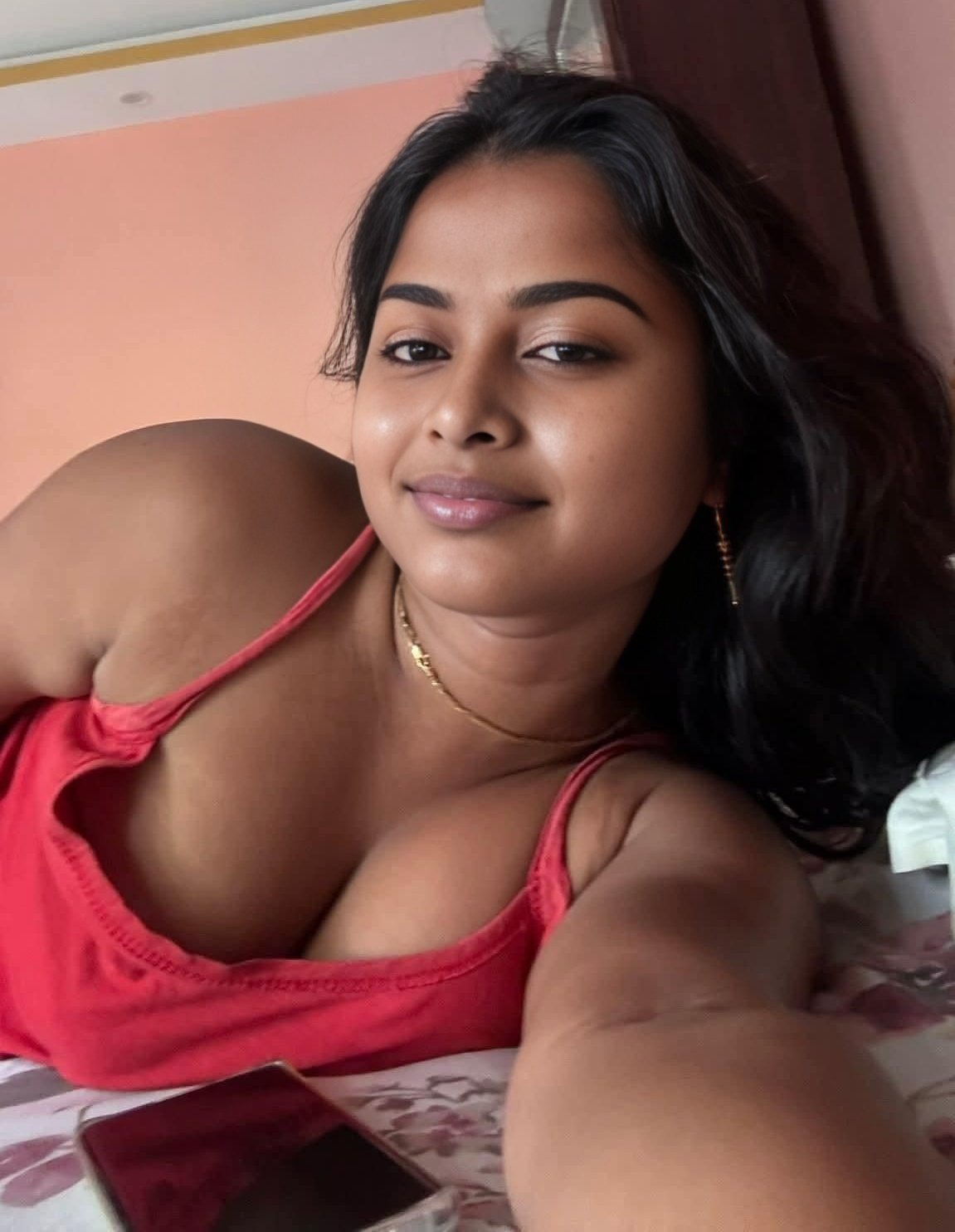 Beautiful Indian bhabhi in red crop top lounging on bed