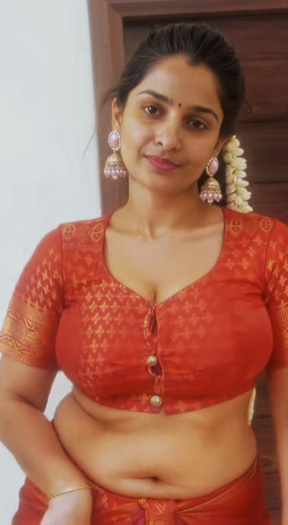 Voluptuous Indian bhabhi in red blouse posing sensually indoors