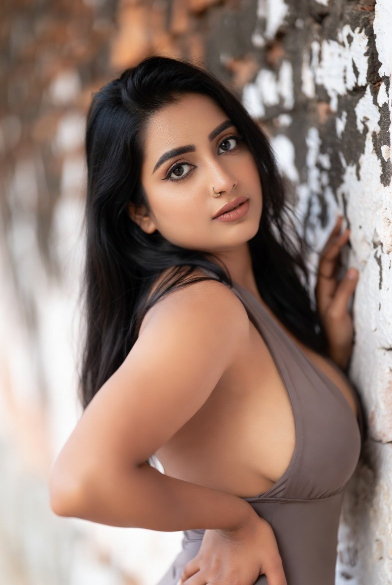Indian woman in gray monokini posing against brick wall