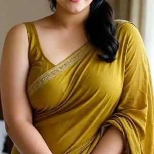 Indian beauty in flowing mustard yellow saree smiling confidently