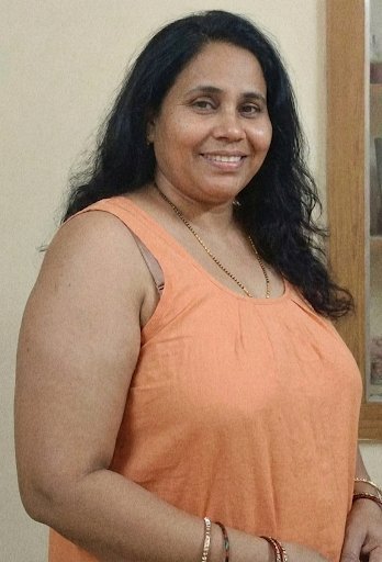 Indian aunty in orange top smiling casually