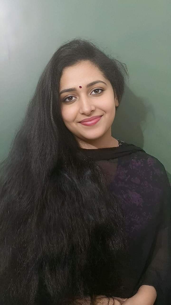 Beautiful Indian girl with long dark hair and bindi posing in black traditional outfit