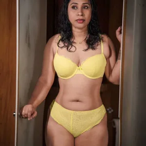 Voluptuous Indian bhabhi wearing yellow lace lingerie posing in doorway