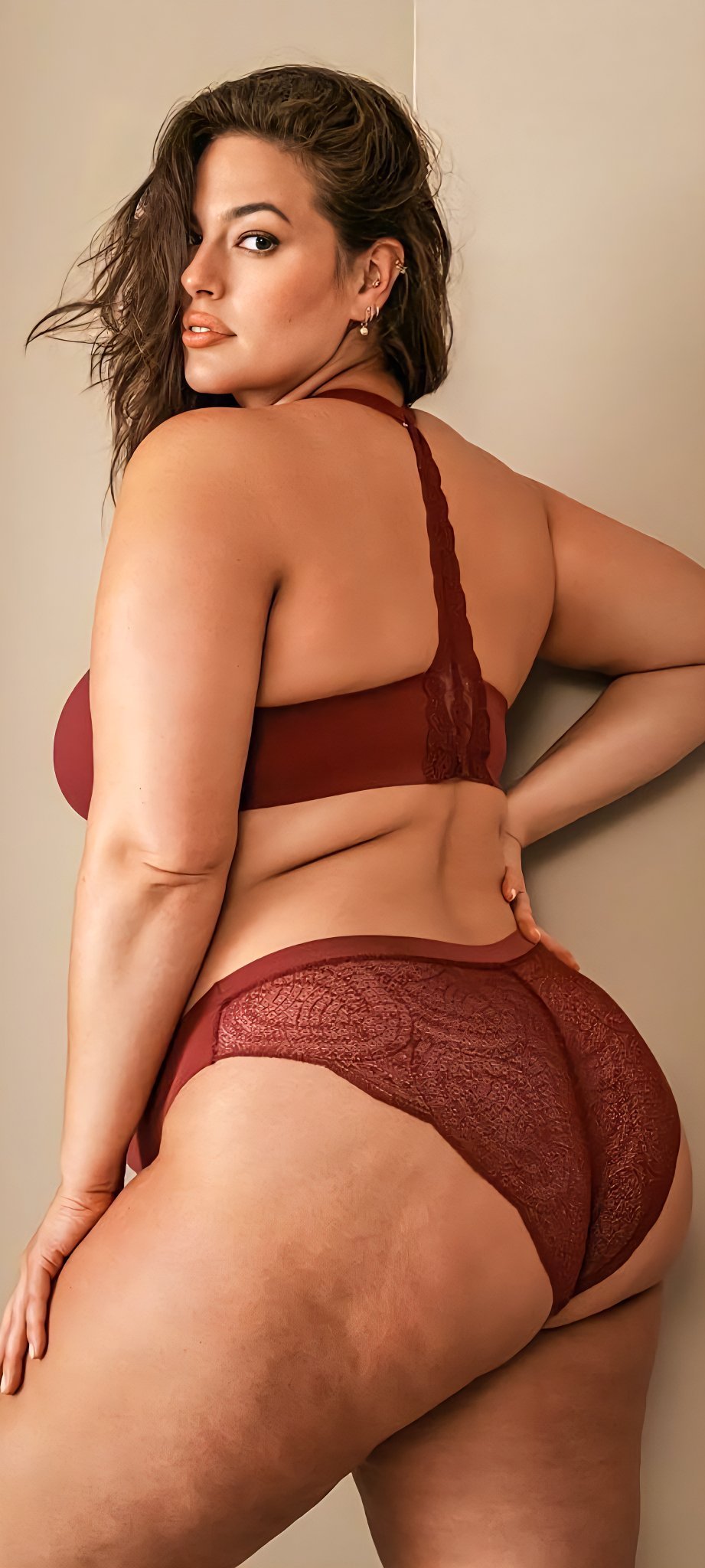 Curvy woman in red lace lingerie posing confidently